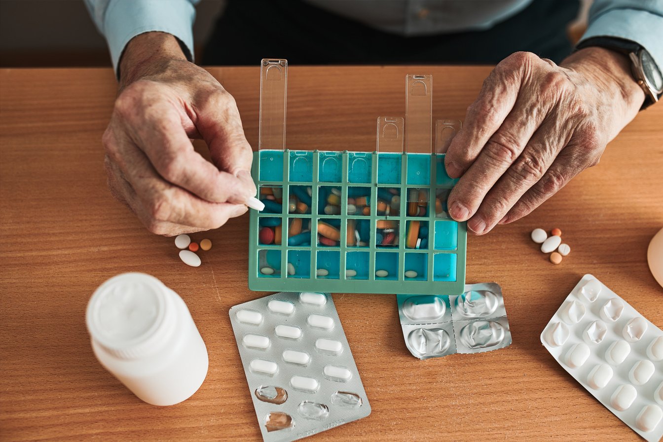 Man Organizing His Medication into Pill Dispenser